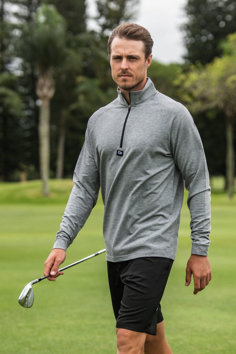 Grey zip-up golf pullover with black shorts and a white club grip.