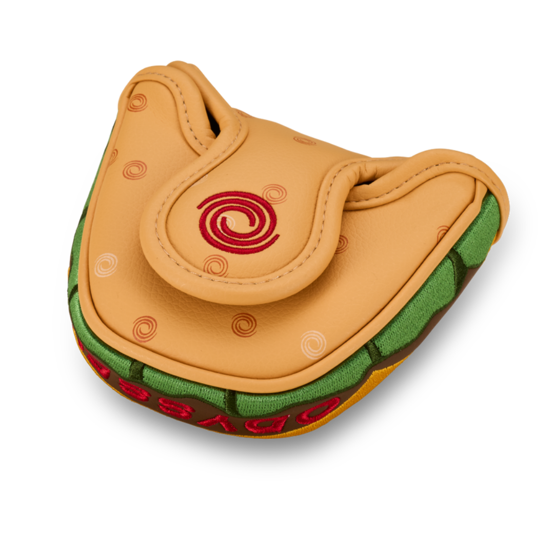 Tan and green taco-shaped golf club head cover with red swirl logo.